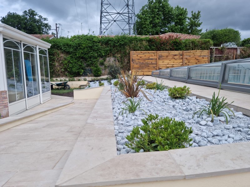 Rénovation de terrasse en grès cérame au Taillan Médoc avec création de massifs et galets décoratifs